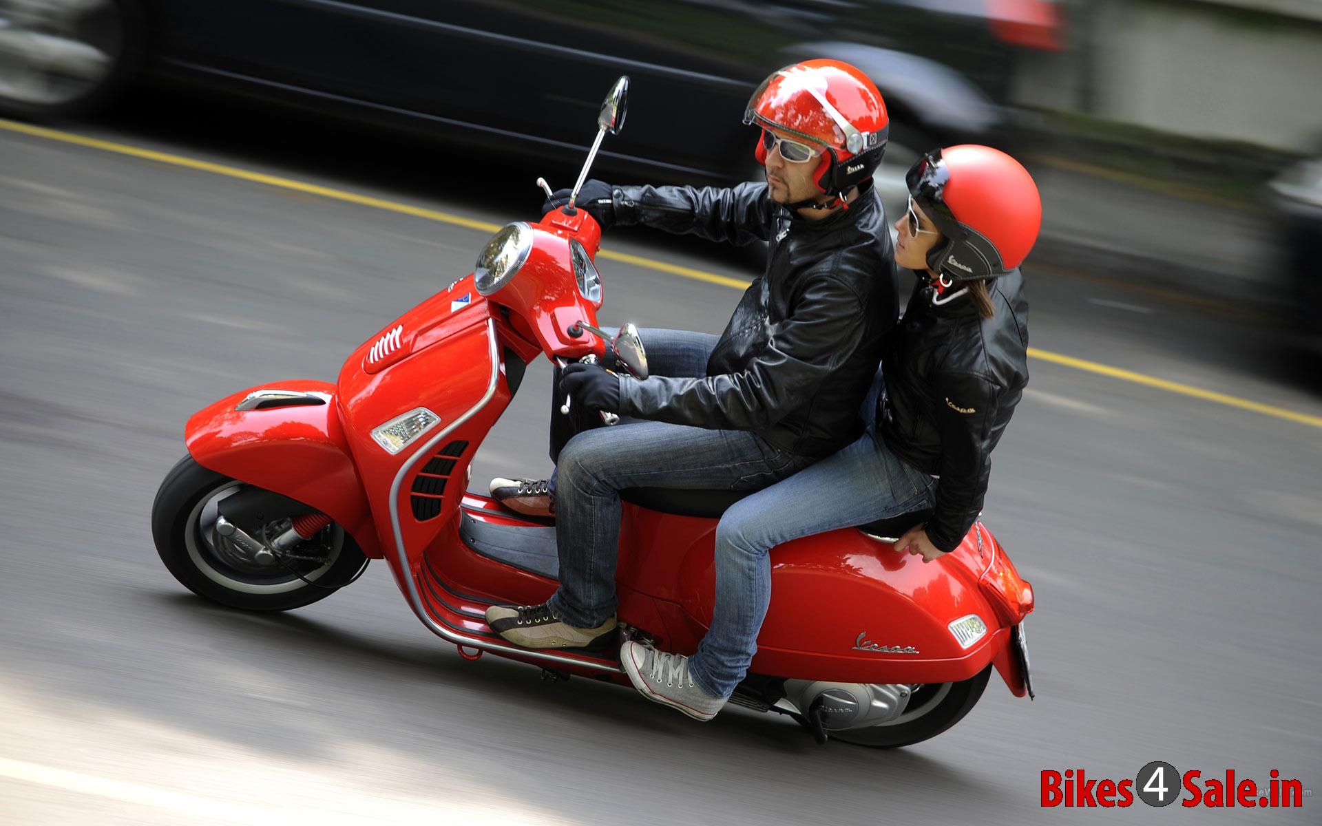 Vespa S 125 - Picture shows, a guy riding the Vespa S 125 of red color with a girl behind him